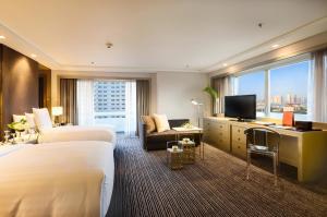 马尼拉Midas Hotel and Casino的酒店客房设有两张床和电视。