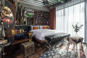 曼谷Mestyle Garage Hotel的一间卧室配有一张床、一张沙发和一张桌子