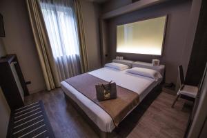 圣佩莱格里诺温泉比吉奥酒店的一间卧室配有一张带镜子和钱包的床