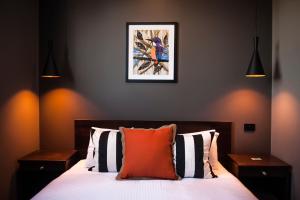 瑟尔Criterion Hotel Sale的一间卧室配有一张带橙色枕头的床
