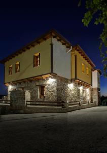 TheológosElaion Terra Boutique Guesthouse的一座大型石头建筑,晚上有灯