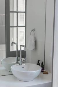 干尼亚Kumba Hostel的浴室设有白色水槽和镜子