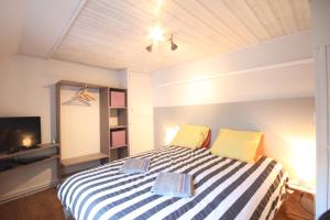 埃特勒塔Entre Mer et Golf的一间卧室配有一张黄色和白色条纹的床