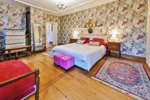 斯特哲兹古恩斯坦城堡住宿加早餐旅馆的卧室配有白色的床和花卉壁纸
