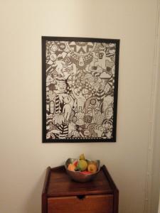 波尔图Apartment Junqueiro的桌上一碗水果,墙上挂着一幅画