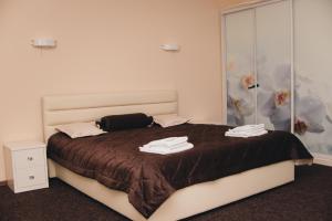 RomnyОрхідея的一间卧室配有一张大床和毛巾