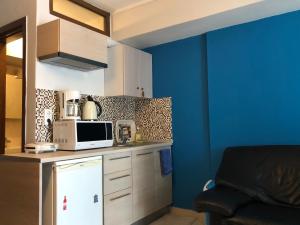 塞萨洛尼基Office-Studio Theoxaris的厨房配有微波炉和蓝色的墙壁