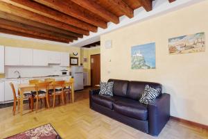 维罗纳Città Antica Charming Flat的一间带真皮沙发的客厅和一间厨房