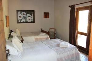 De RustRibboksfontein Guest Farm的一间卧室设有两张床和窗户。