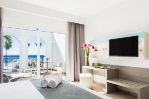 甘迪亚海滩Royal Palm Resort & Spa - Adults Only的酒店客房,配有床和电视