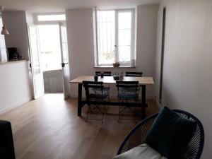 巴约讷Appartement au coeur de Bayonne sur les remparts的一间用餐室,在房间内配有桌椅