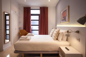 马德里Gran Central Suites的一间卧室配有一张带椅子的床和一扇窗户