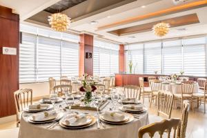 圣地亚哥洛斯卡巴霍德帕中央广场酒店的用餐室设有桌椅和窗户。