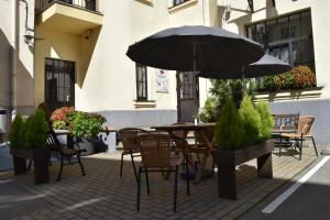 里加Hotel Edvards的庭院配有桌椅和遮阳伞。