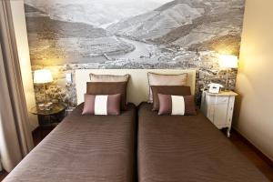 波尔图Oca Ribeira do Porto Hotel的一张床上有两个枕头的房间