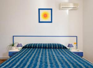 托雷瓦多Al Porticciolo的一间卧室配有蓝色的床和2个床头柜
