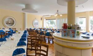 托雷瓦多Al Porticciolo的一间配备有桌椅及蓝色弓的用餐室
