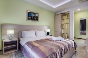 赫尔采格诺维Riva Residence的一间卧室配有一张大床和两条毛巾