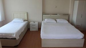 埃杰阿巴德Bahçeli Konak的小客房内的两张床,配有白色床单