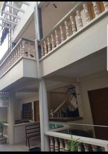 长滩岛Madid's Inn Beach Resort的一座带大阳台的建筑,设有楼梯