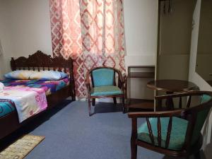 长滩岛Madid's Inn Beach Resort的一间卧室配有两张床和一张桌子及椅子