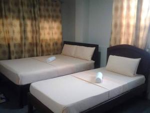 长滩岛Madid's Inn Beach Resort的两张睡床彼此相邻,位于一个房间里