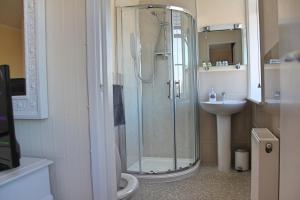 韦茅斯The Anchorage的带淋浴、卫生间和盥洗盆的浴室