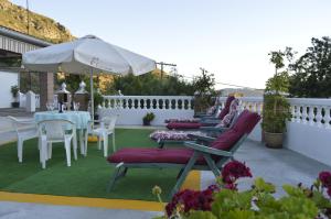 兰哈龙Casa Los Barranquillos的庭院配有桌椅和遮阳伞。