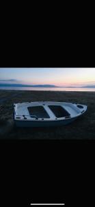 OrfánionOfrinio Beach Cosy & Relaxing的日落时坐在海滩上的白色小船