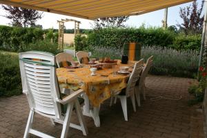 Orgères-la-Roche博韦草原B＆B旅馆的一张桌子、白色的椅子和黄色的桌布
