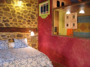 San Miguel del RobledoJardines del Robledo-Albar的一间卧室设有一张床和石墙