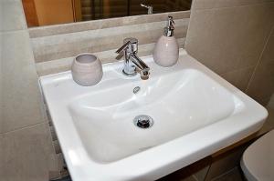 杰尔Downtown Apartments DeLuxe的白色浴室水槽,有两杯