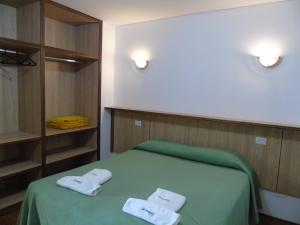 波萨达斯芦荻公寓酒店的一间卧室配有绿床和毛巾