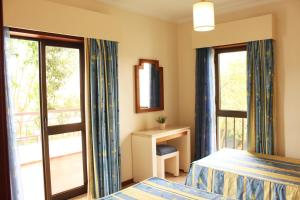 波尔蒂芒Apartamento Praia Vau T1的酒店客房设有一张床和一个阳台。