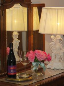 维罗纳卡萨潘维尼奥酒店的桌上一瓶葡萄酒,带一盏灯和鲜花