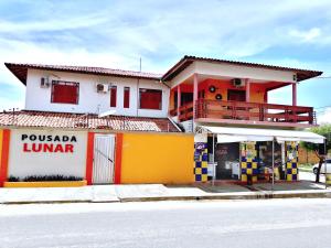 巴纳伊巴Pousada Lunar的黄色和白色的建筑,街上有商店