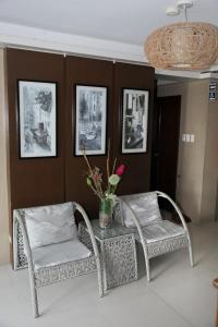 杜马格特最佳酒店的两把柳条椅和一张带花瓶的桌子