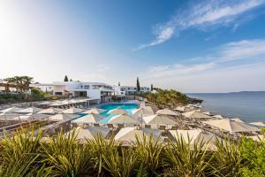 波多河丽Hapimag Resort Porto Heli的一个带游泳池和遮阳伞的度假胜地和大海