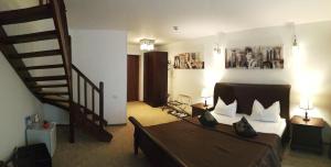 布什泰尼科纳克巴伐利亚酒店的一间带大床和楼梯的卧室