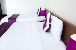 邦美蜀二征温泉酒店 的配有紫色灯的酒店客房内的两张床
