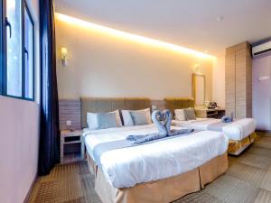 八打灵再也GM Grand Moments Bandar Sunway的酒店客房设有两张床,上面有蓝色填充动物