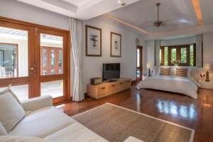 莱利海滩Villa Macaque and Villa Languor的一间带床和电视的客厅