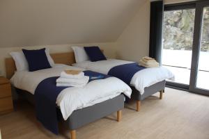 威廉堡Wilderness Apartments的一间卧室配有三张床,铺有蓝色和白色的床单