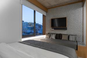 雅典Ergon House Athens的一间卧室配有一张大床和一台平面电视