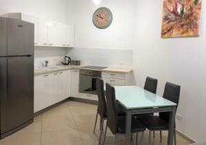 耶路撒冷Saidoff Luxury Residence的厨房配有桌椅和冰箱。