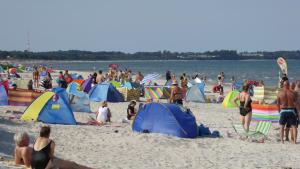 京斯特Ferienhaus Gut Rattelvitz Insel Rügen的一群人在海滩上,有帐篷
