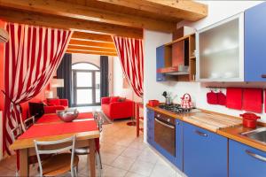 威尼斯Stella Marina 3的厨房以及带红色桌椅的起居室。