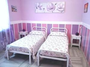 都灵塞雷内拉酒店的配有粉红色墙壁的客房内的两张床