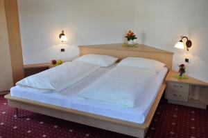 纳兹-夏韦斯Trinnerhof的卧室内的一张大床,配有两个枕头