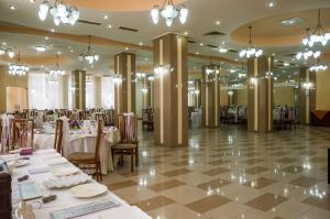 布勒伊拉特瑞安酒店的宴会厅配有白色的桌椅和吊灯